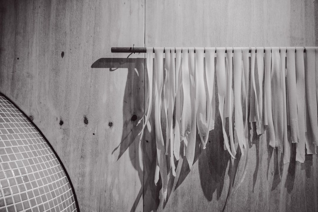 White pasta drying on a rack indoors.