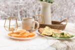 white ceramic pitcher beside clear drinking glass on white table cloth