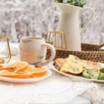 white ceramic pitcher beside clear drinking glass on white table cloth